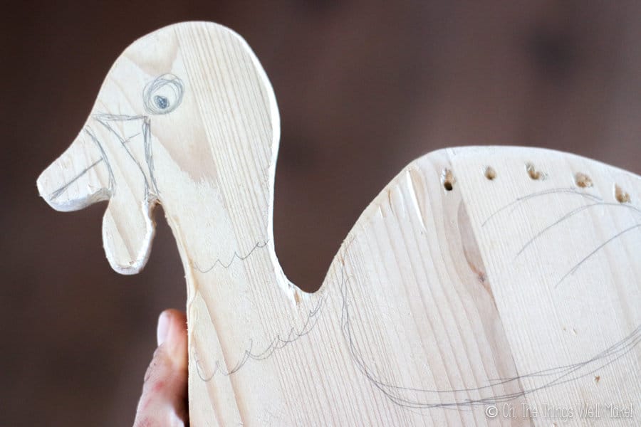 drawing a face and wings on a wooden turkey display for bamboo skewers
