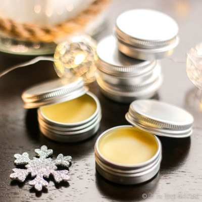 Solid perfume in tins surrounded by lights.