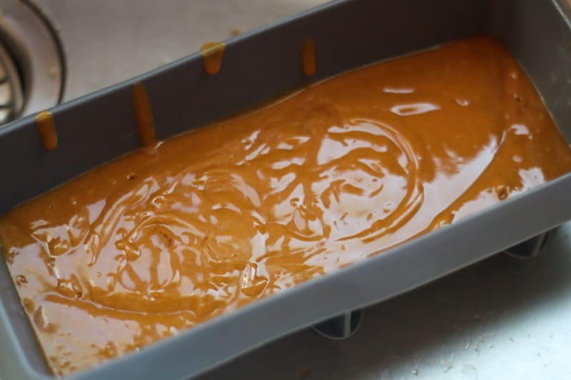 A silicone loaf pan filled with the homemade gingerbread soap mixture