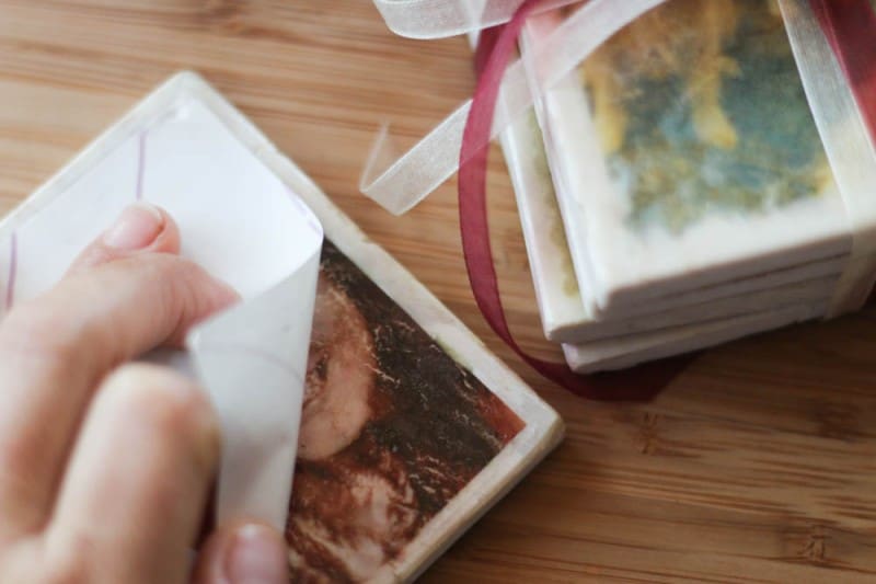 Peeling off the backing paper of a t-shirt transfer on a marble tile