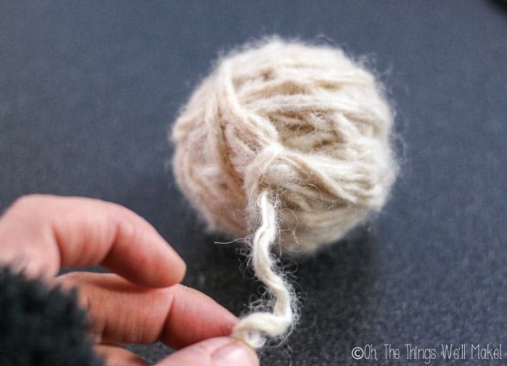 a 6cm diameter ball of yarn with a free end of yarn sticking out. 