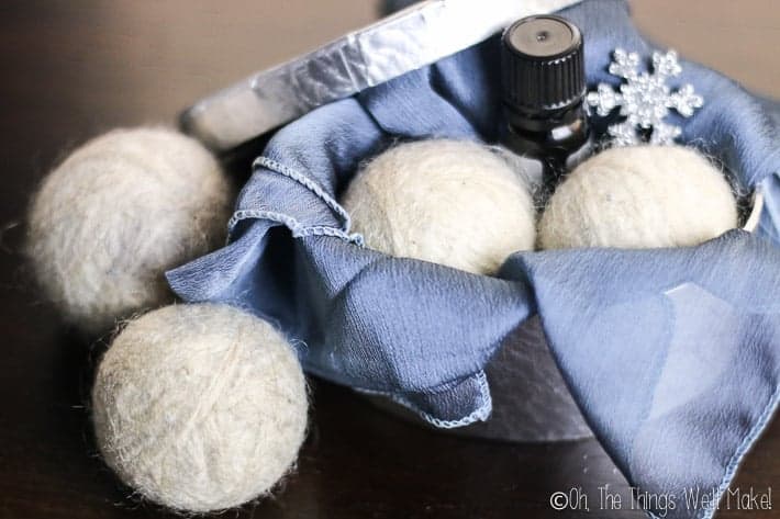 4 wool dryer balls, two of which are in a pretty silver box, ready for gifting.