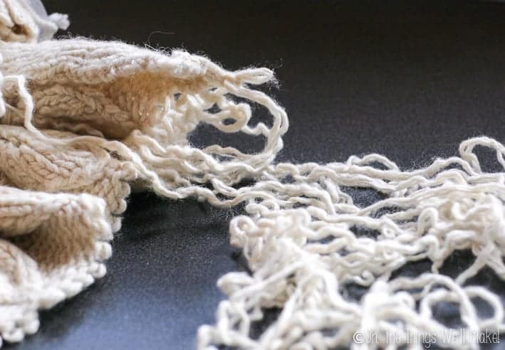wool being unraveled from an old wool sweater.