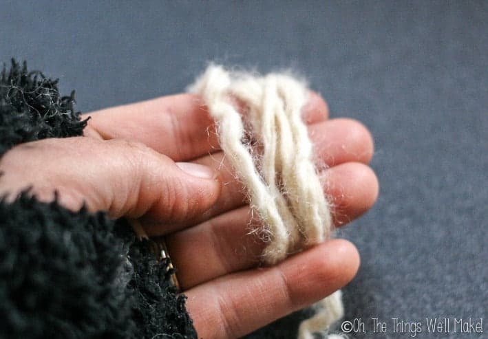 A strand of wool being wrapped around my fingers