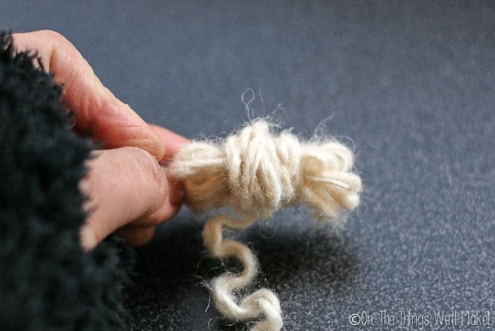 a small ball of wool os being formed by wrapping more wool around the first wound pieces