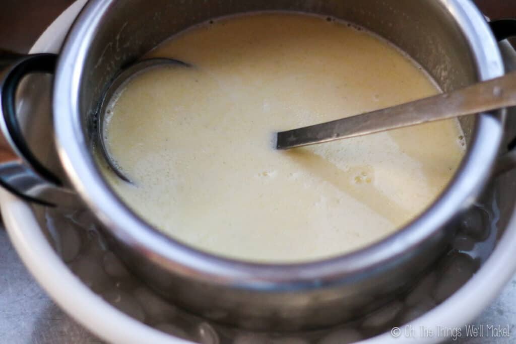 a pan filled with a cream mixture inside a bowl of ice.