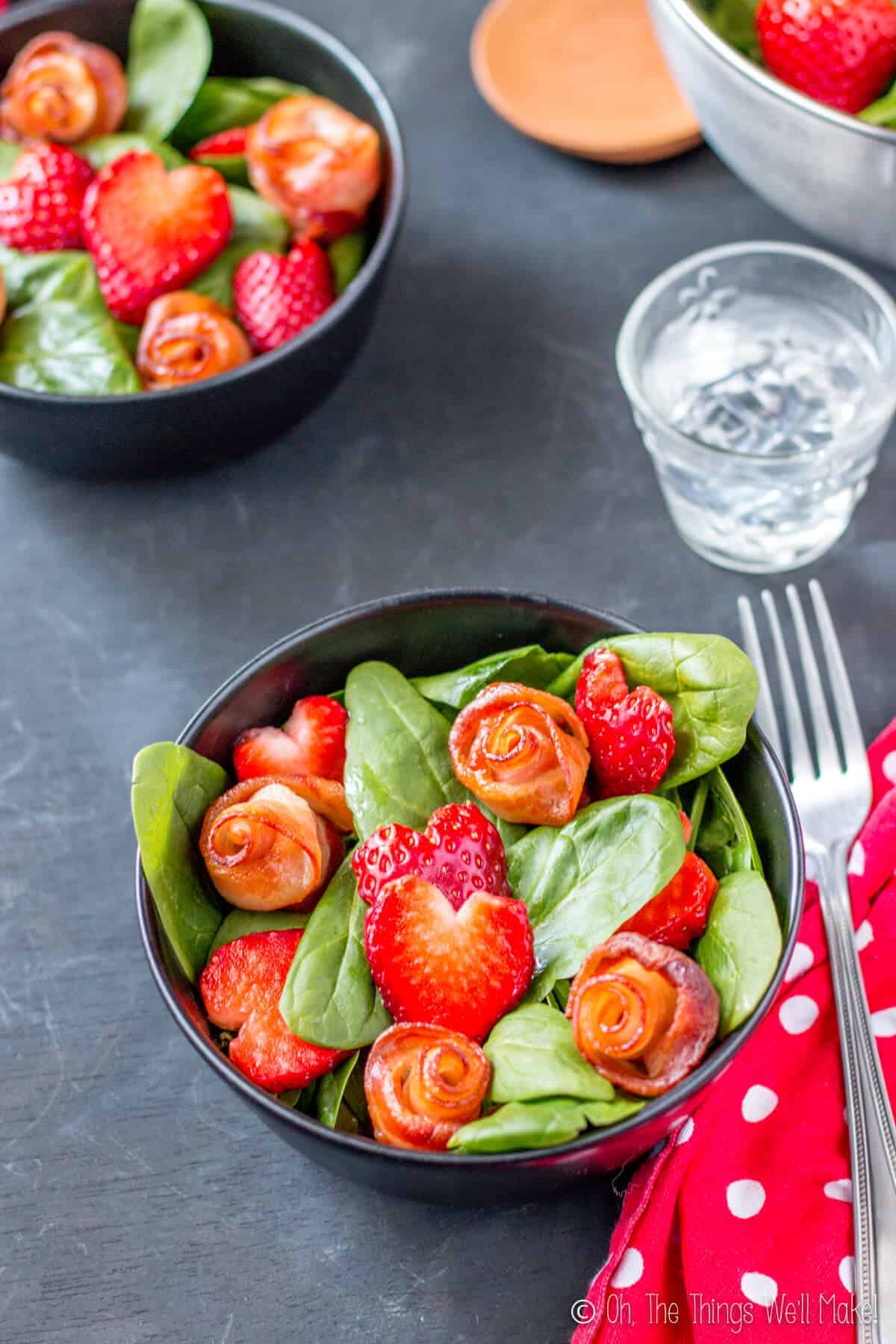 Overhead view of two Valentine's Day salads with bacon roses and strawberry hearts