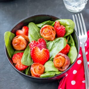 Closeup of a cute salad, perfect for Valentine's Day! It has strawberry hearts and bacon roses.