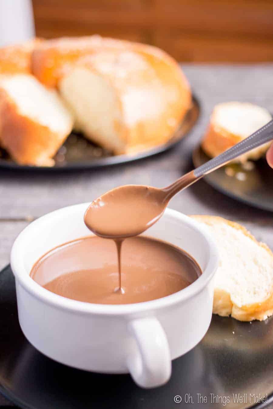 Spooning up a thick, Spanish hot chocolate known as chocolate a la taza. In this case, it's being served with pan quemado, a Spanish sweet bread typical at Easter.