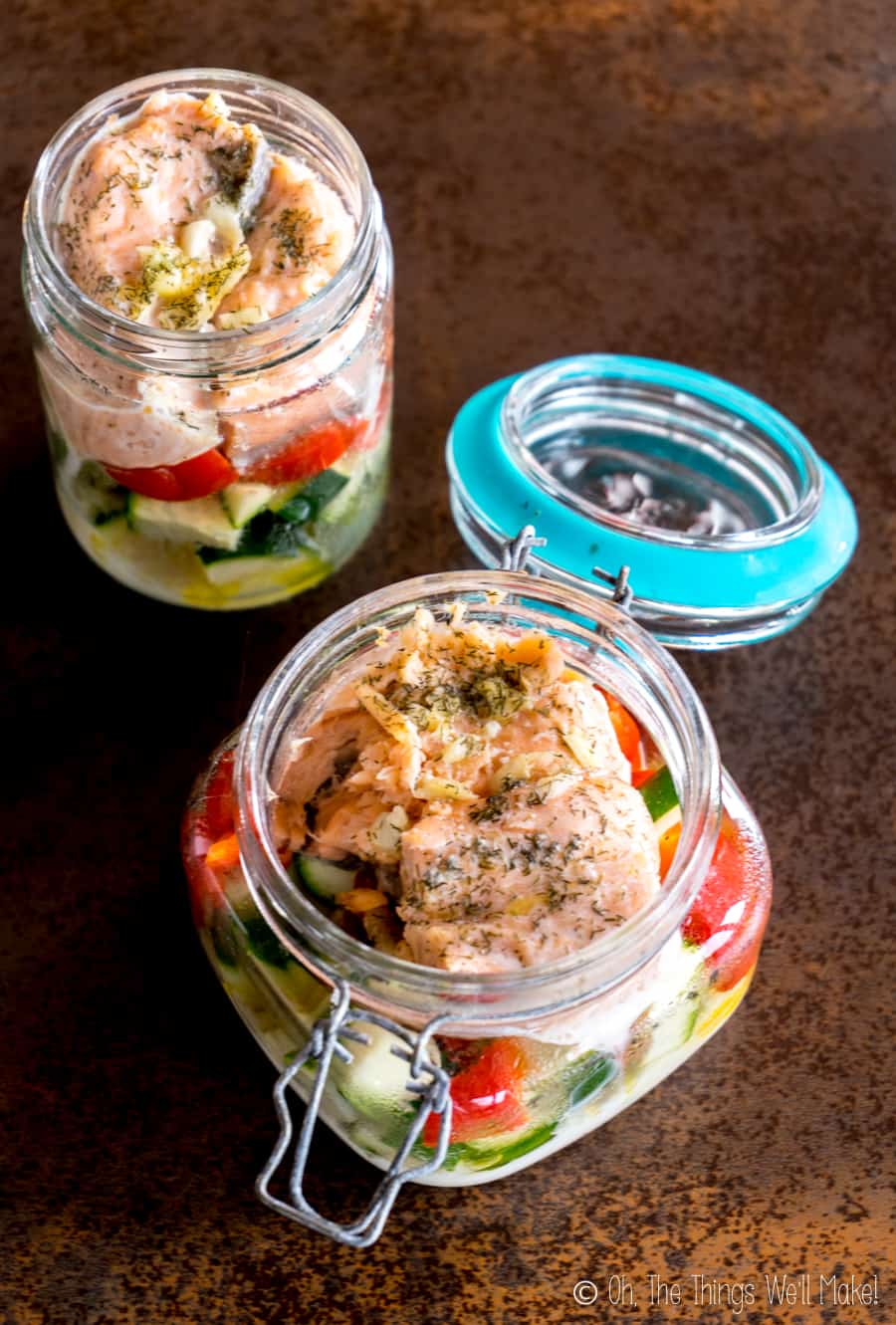 Overhead view of salmon and cut veggies that were cooked in jars in the dishwasher.