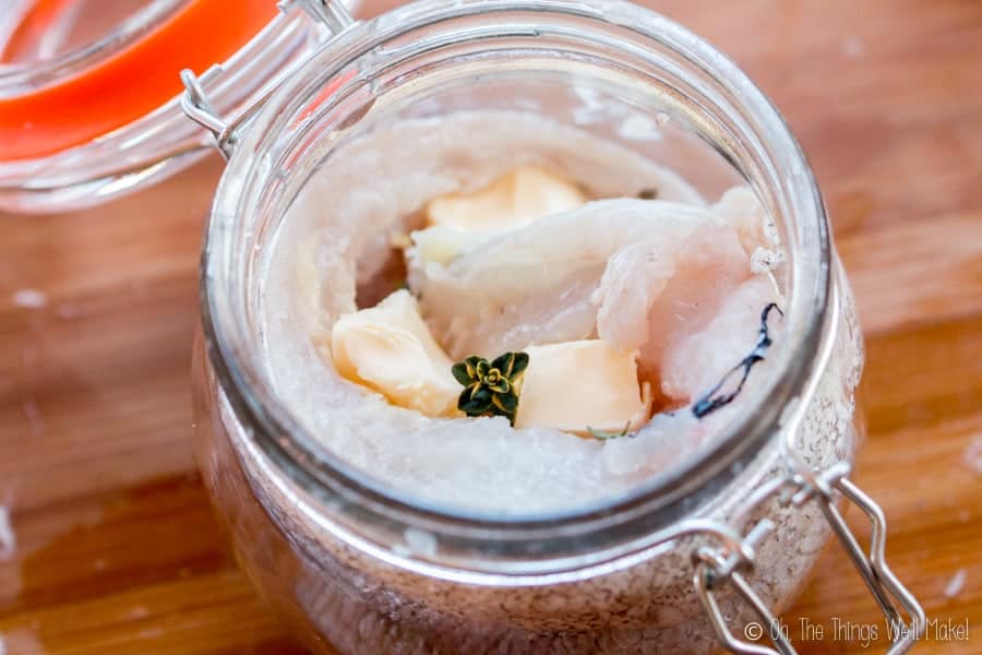 Overhead view of hake in a jar with butter and thyme, ready for cooking in the dishwasher.