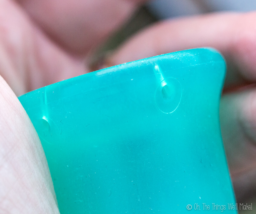 Closeup of the rim of the Sckoon menstrual cup, showing the diagonally placed holes.