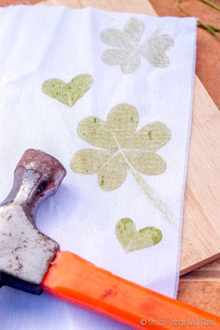 A white cloth with shamrock prints and clover heart prints.