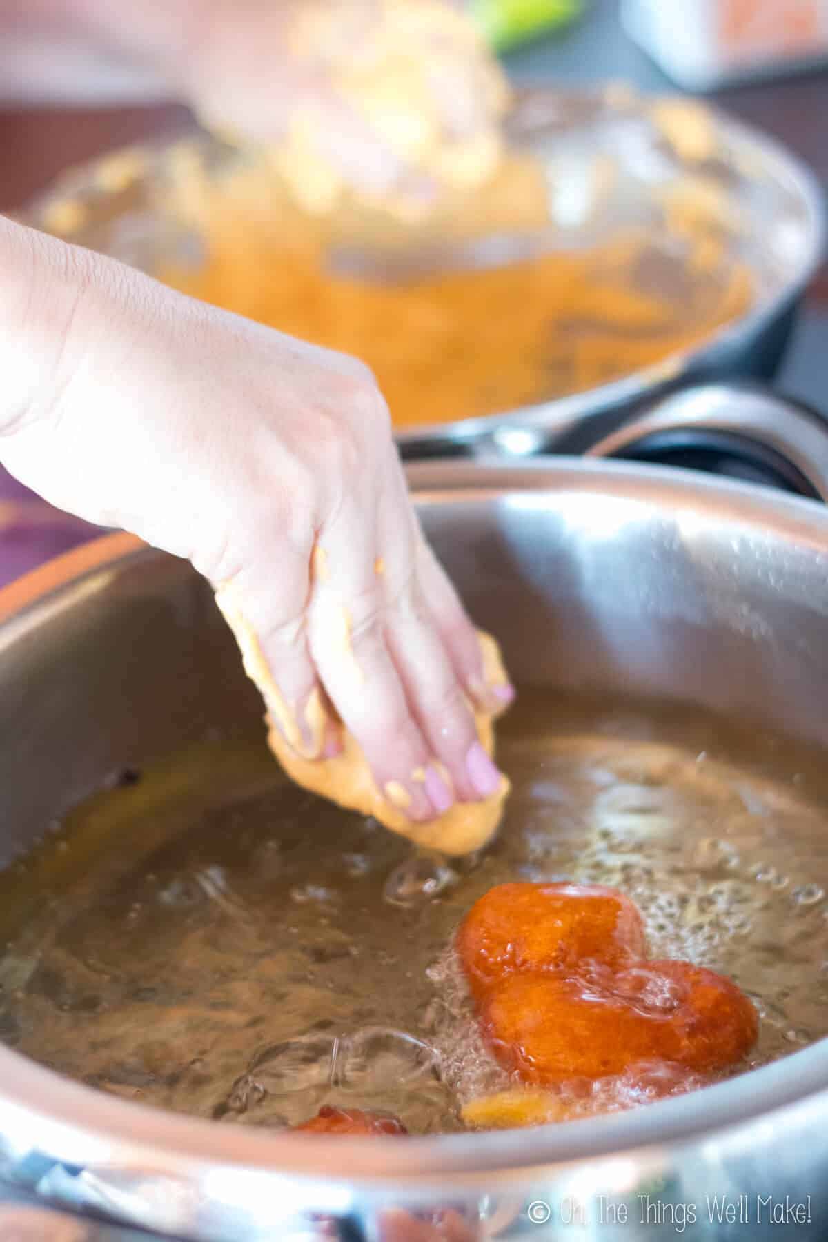 Adding pumpkin fritter batter to hot oil