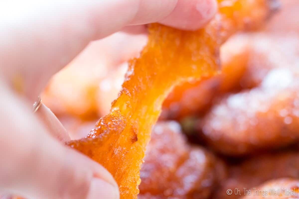 Pulling apart a pumpkin fritter to show it's elastic texture.