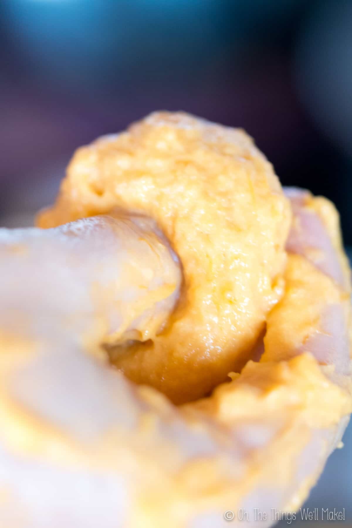 Poking a hole in the batter of a pumpkin fritter.