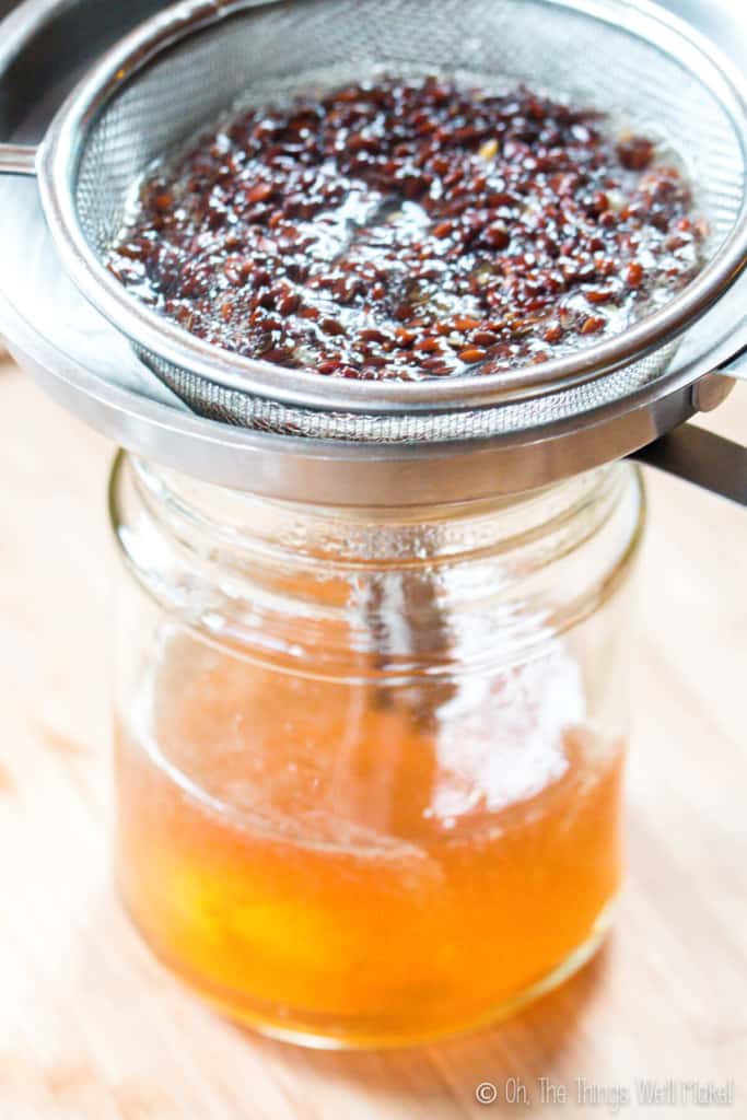 Straining out flaxseed gel through a strainer in a funnel into a glass jar below