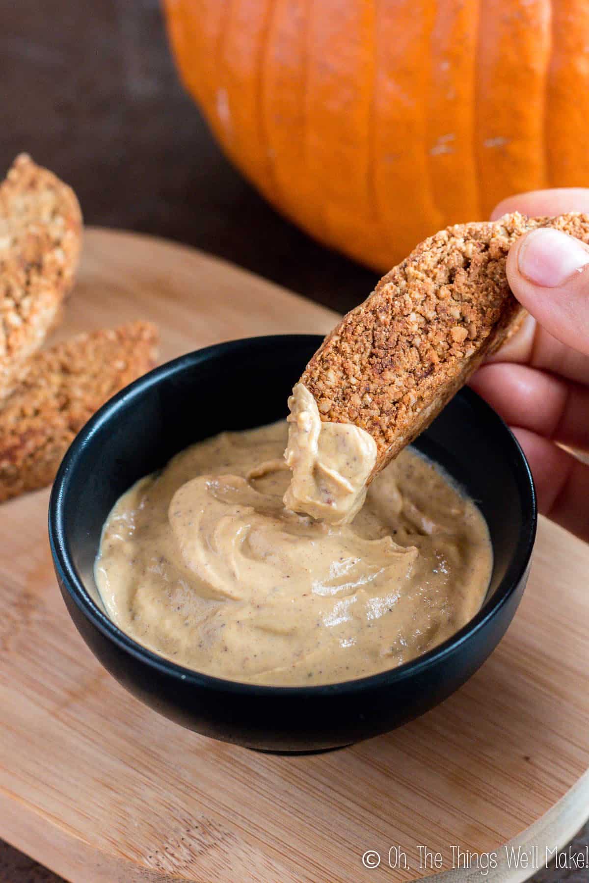 dipping pumpkin pie biscotti into a sweet pumpkin pie dip