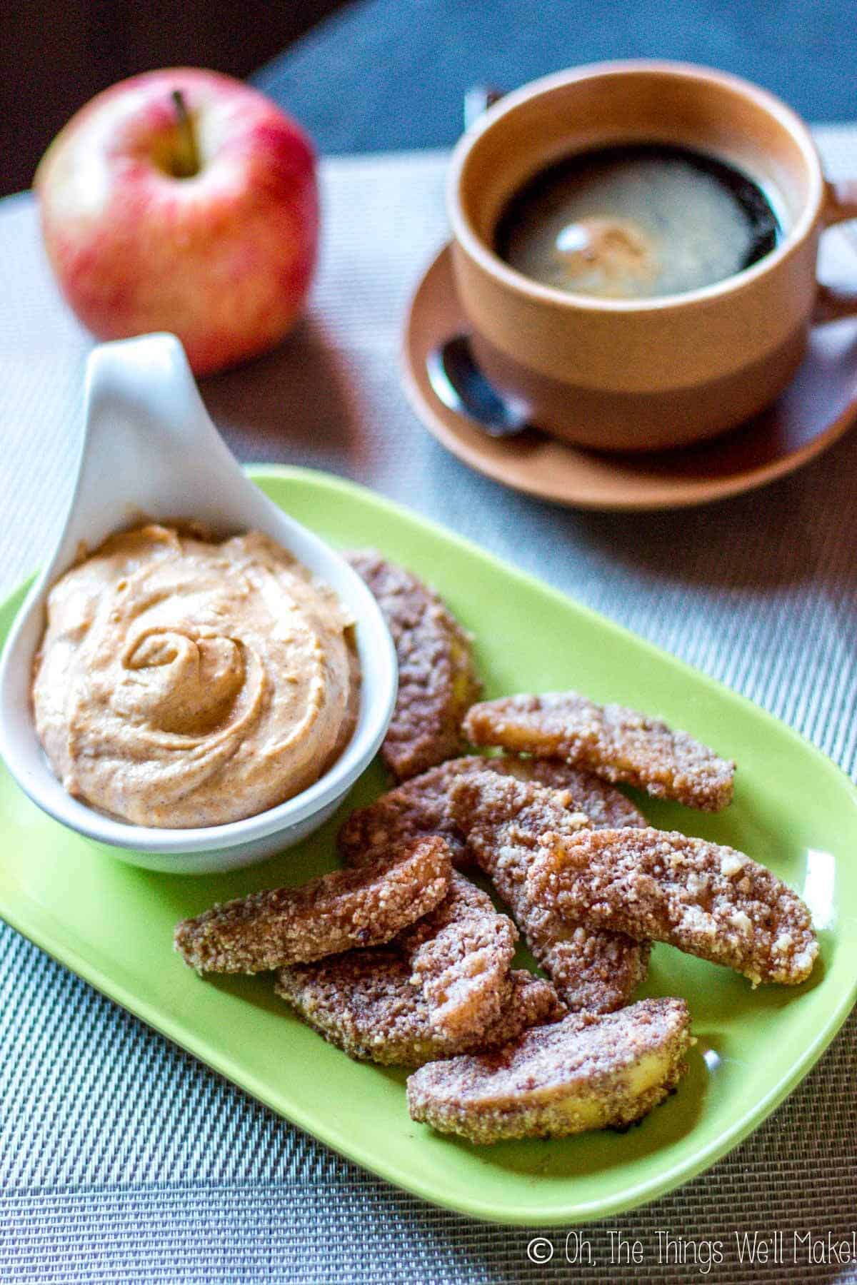 Paleo baked apple fries on a plate with pumpkin pie dip, served with coffee