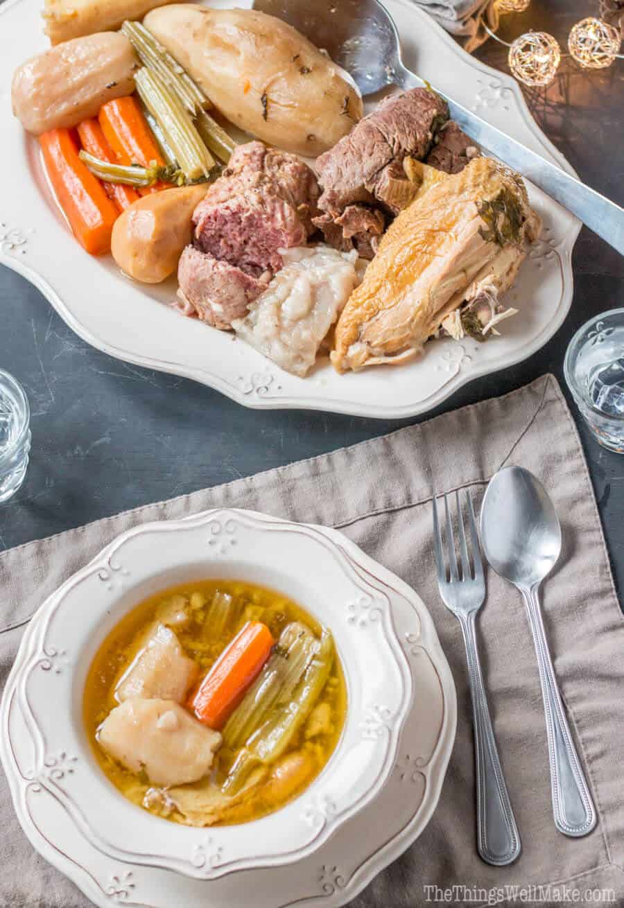 Overhead view of a plate of Valencian puchero and a bowl with broth and veggies