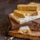 3 different types of turrón on a rustic looking wooden cutting board.