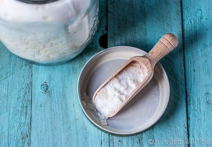 powdered homemade laundry detergent shown in a wooden scoop