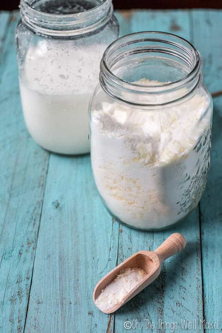 Two mason jars filled with homemade laundry detergents. One shows a powdered version while the other shows a liquid version.