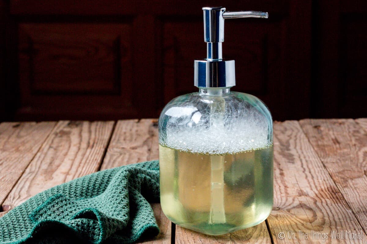 homemade liquid soap in a soap dispenser in front of a washcloth