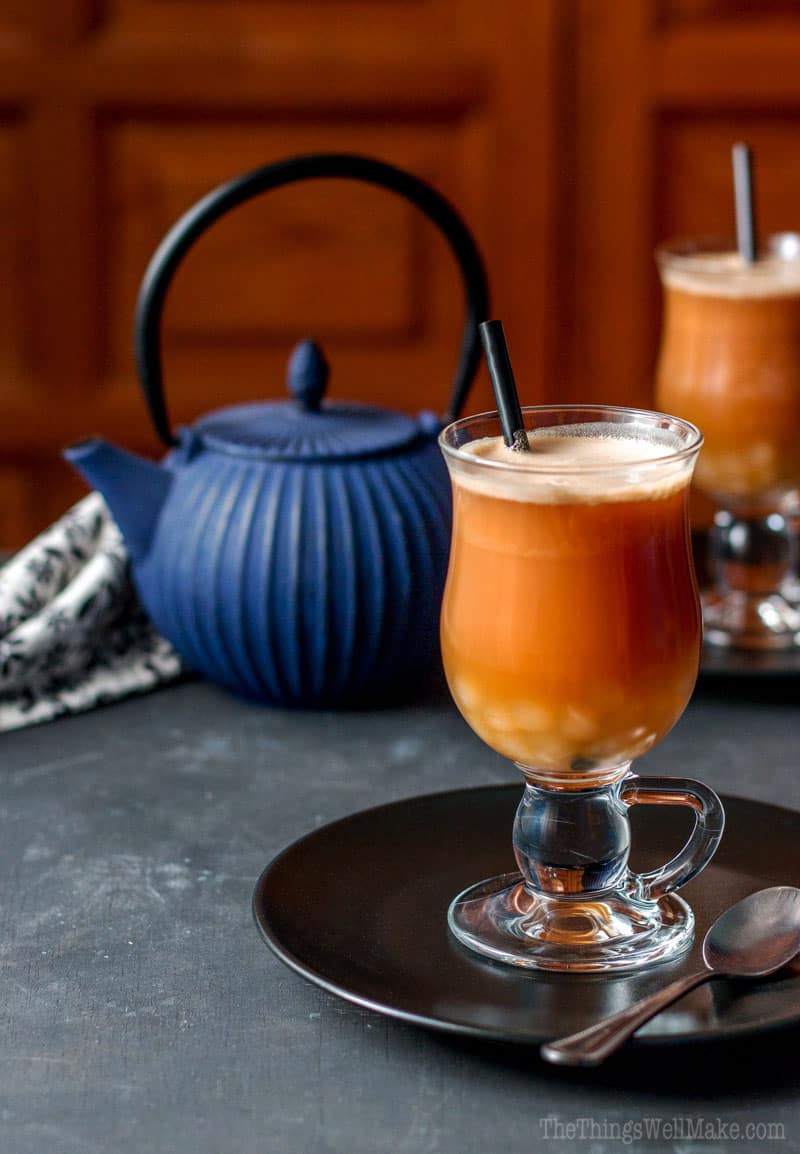 A chai latte with homemade boba in the bottom of the glass.