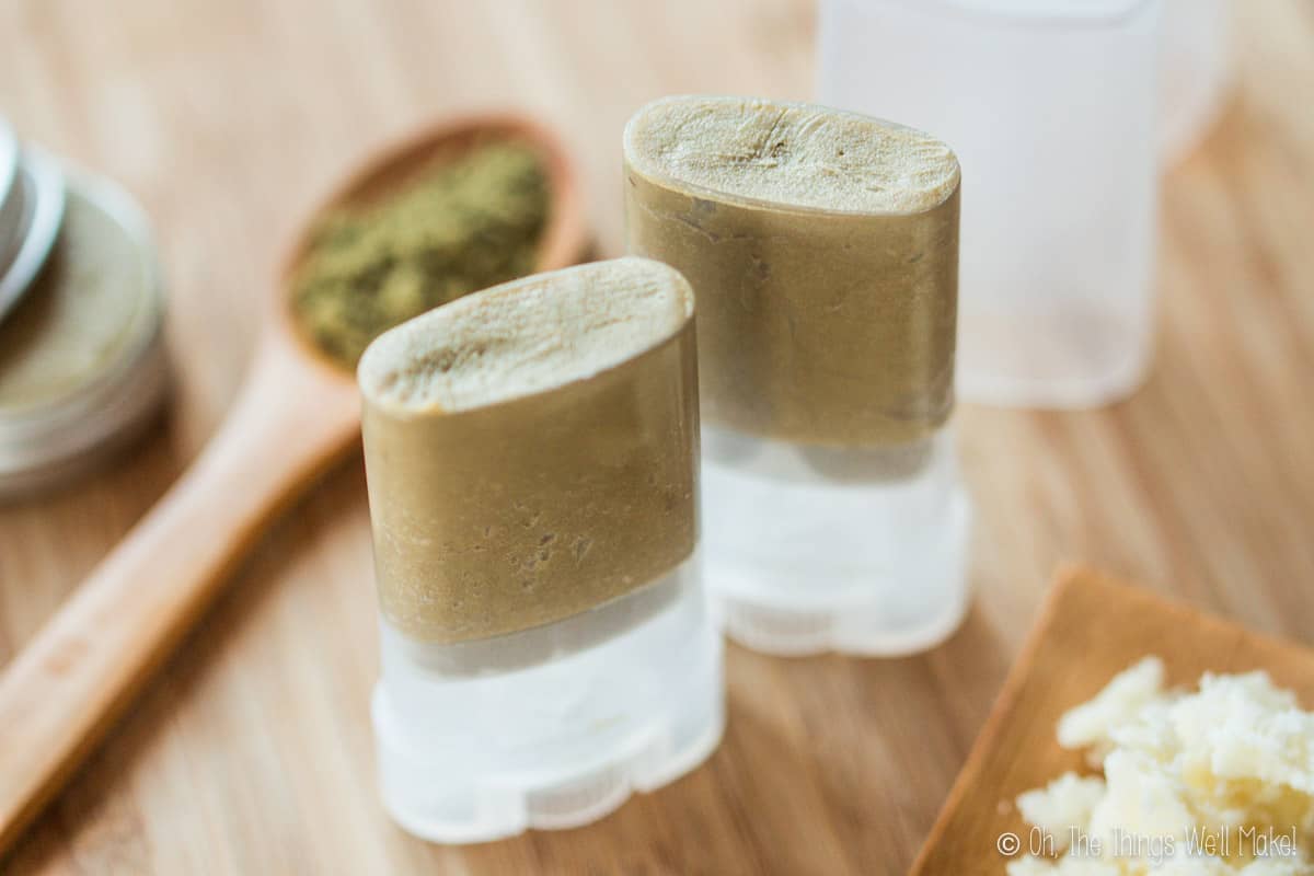 Overhead view of two tubes of homemade deodorant surrounded by ingredients for it.