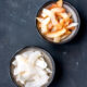 Overhead view of 2 bowls of coconut chips, one with toasted chips