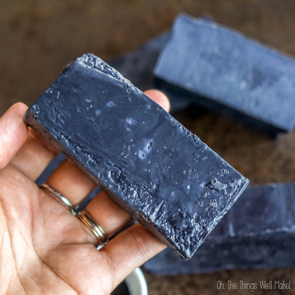 Activated charcoal soap bar for oily or acne-prone skin, held in hand