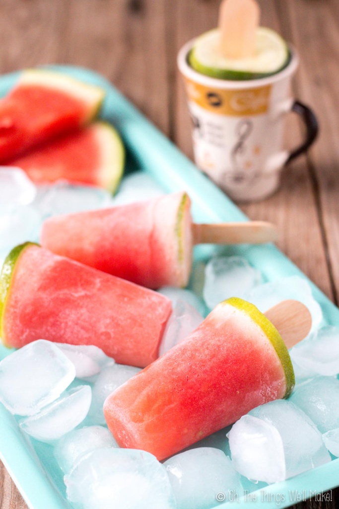 watermelon gelatin popsicles on a tray with ice