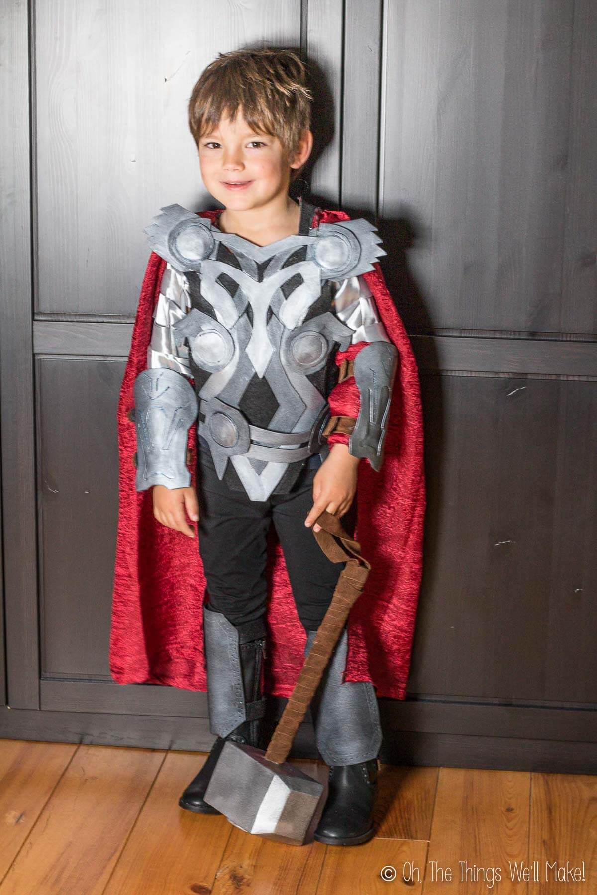 A boy dressed in a Thor costume without the helmet on