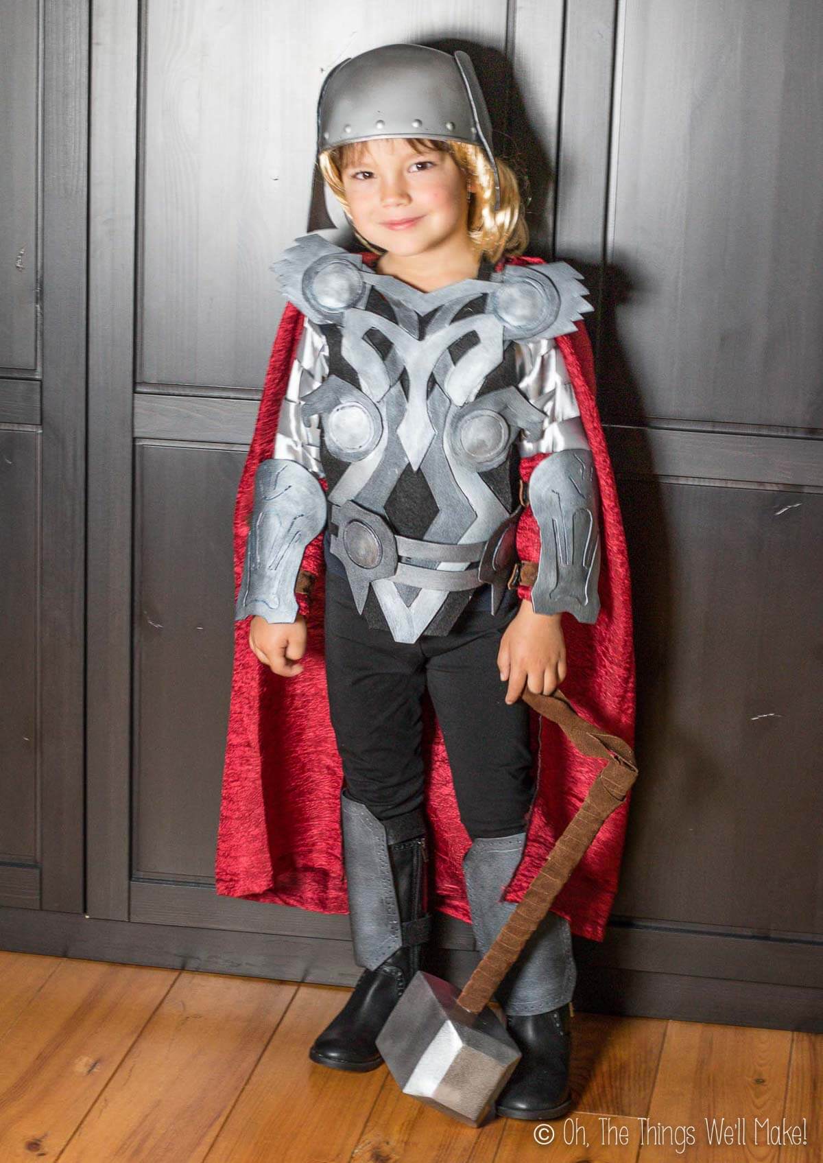 A boy dressed in a Thor costume with the helmet on