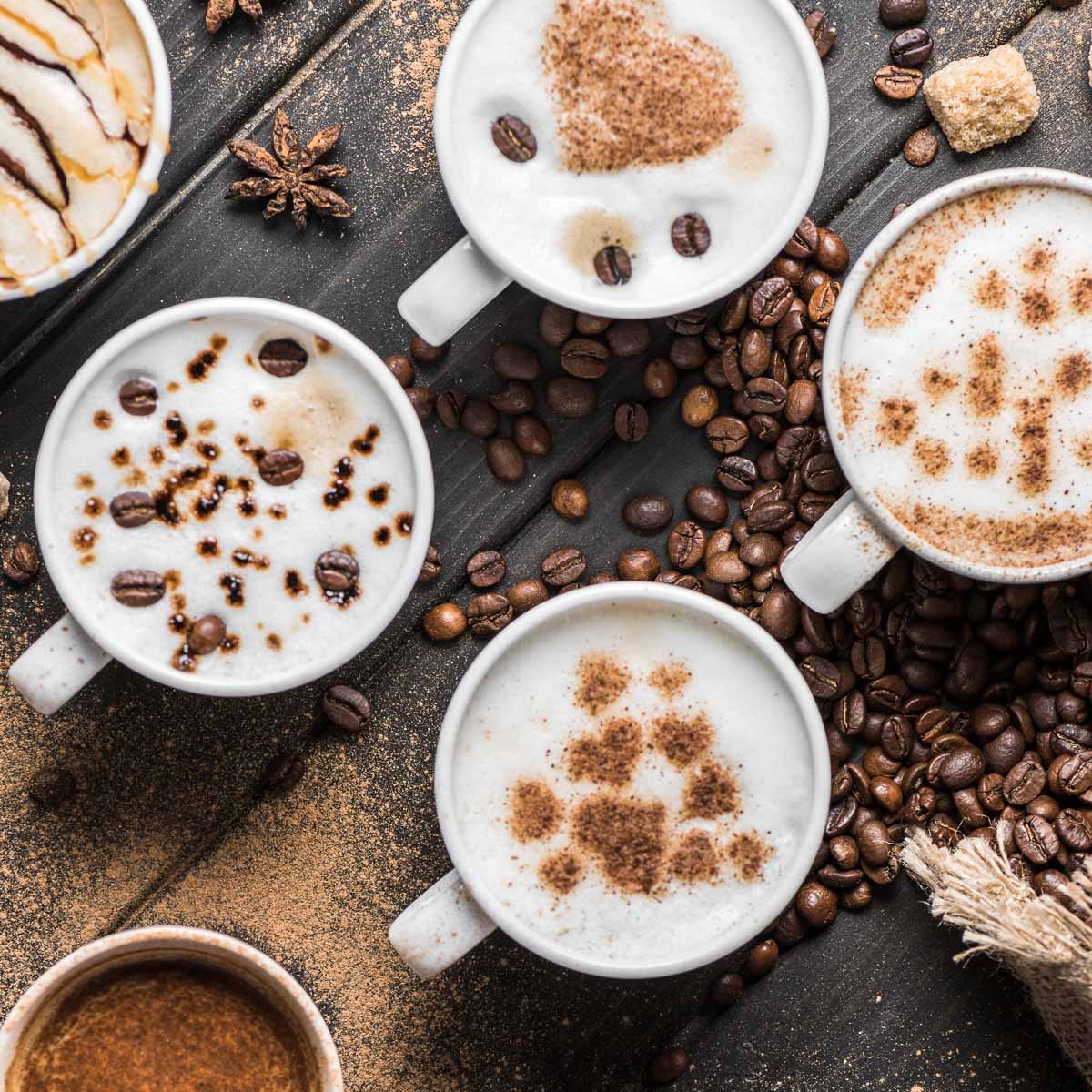 Overhead view of several cups of coffee flavored in different ways.