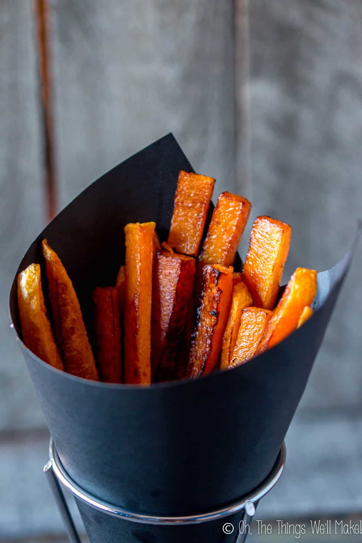 baked pumpkin fries in a black paper cone