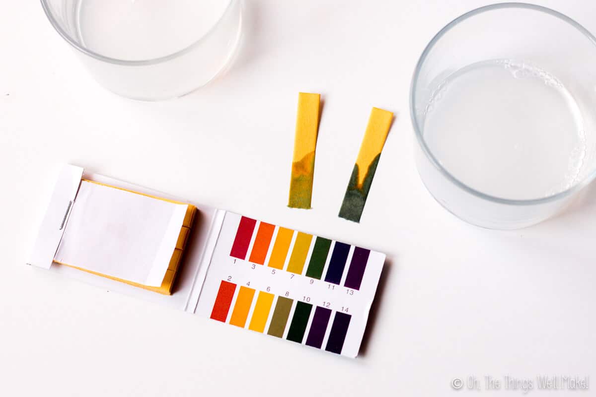 Closeup view of two pH test strips, one with a reading of around 9-10 and another at a pH 8-9.