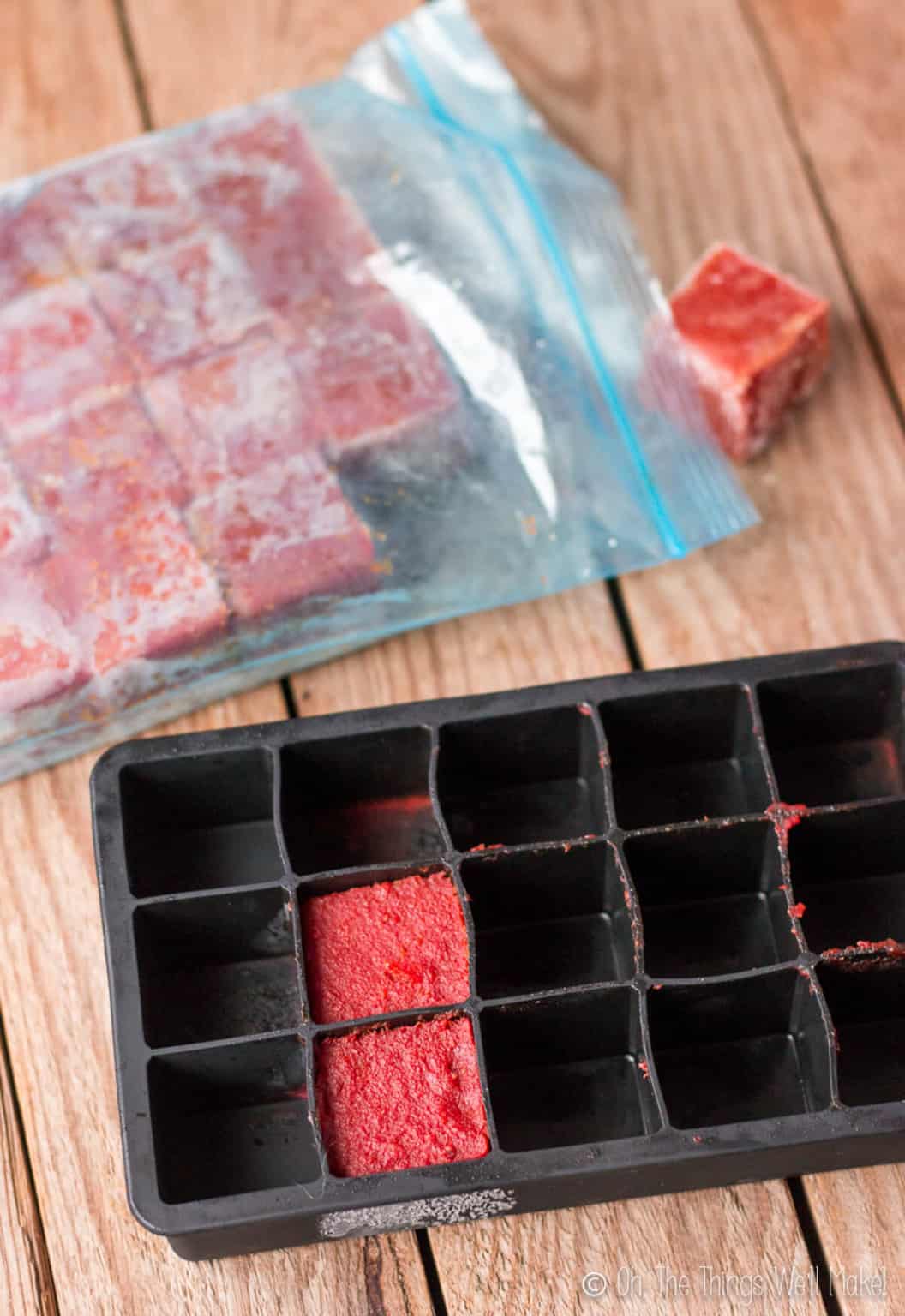 Overhead view of homemade tomato paste in ice cube trays for freezing and storing.