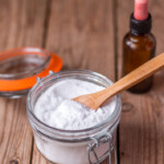 a jar of baking soda with an essential oils bottle