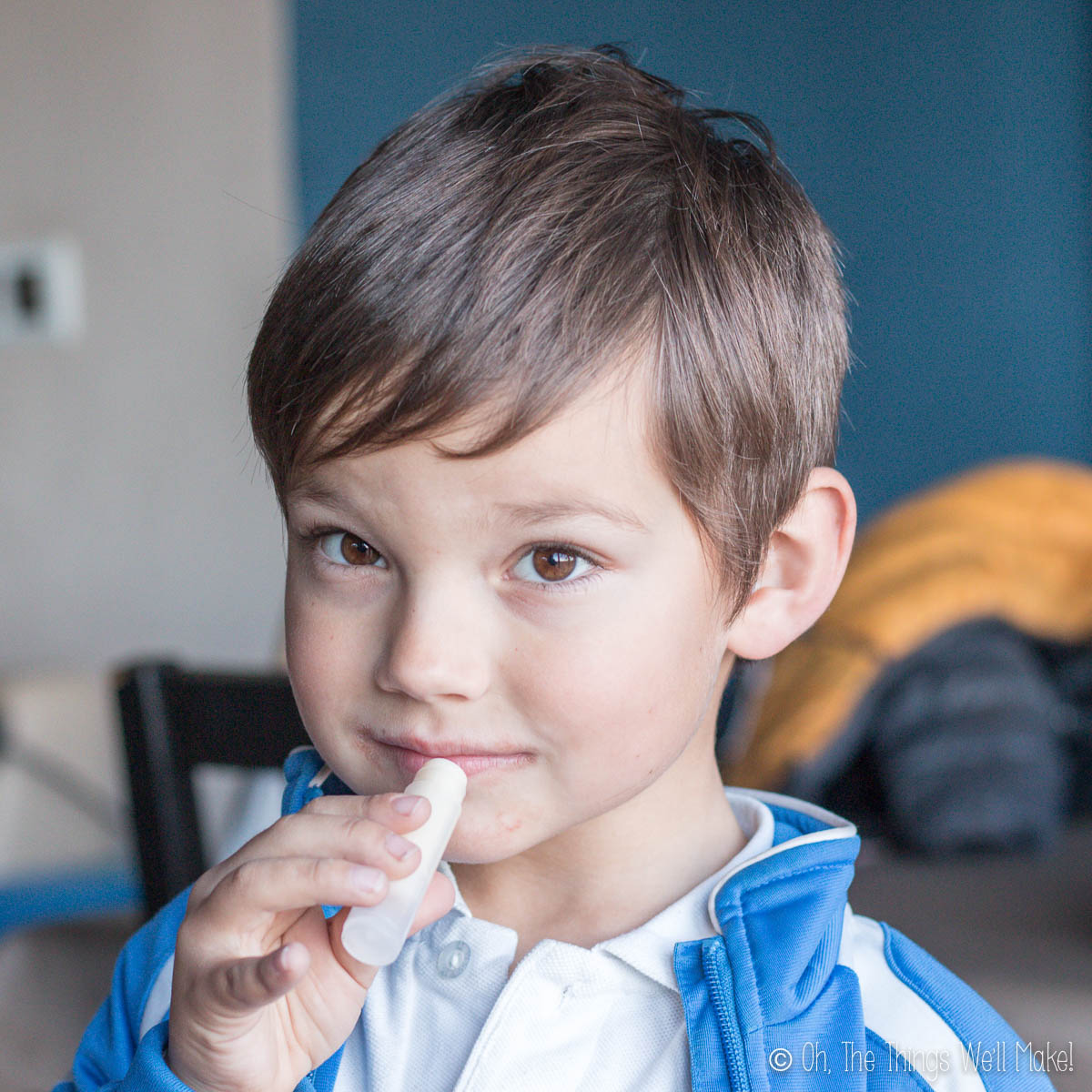 A small boy applying a homemade lip balm