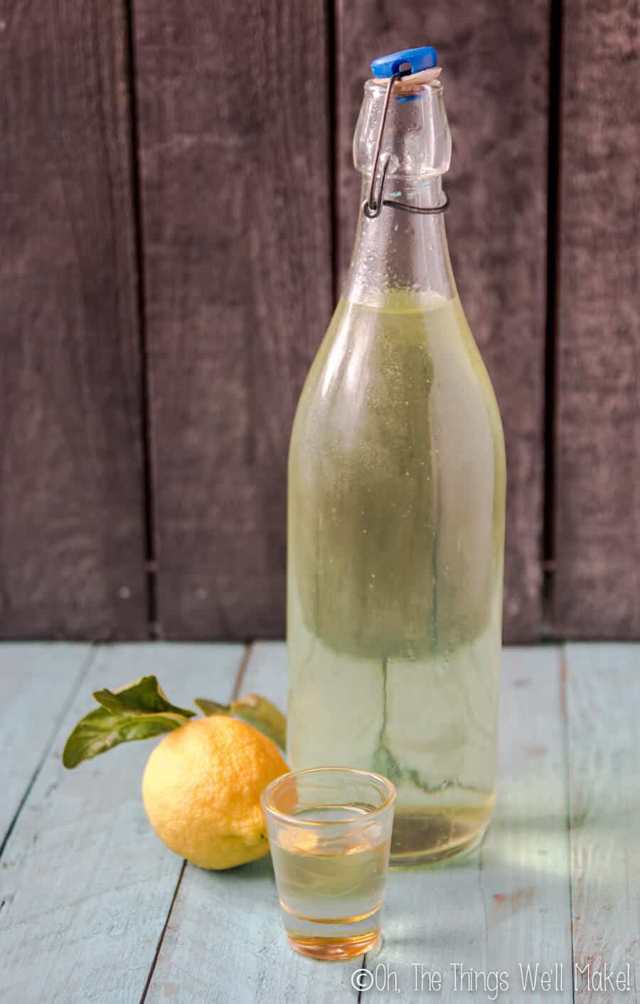 A bottle of homemade limoncello that is paler in color