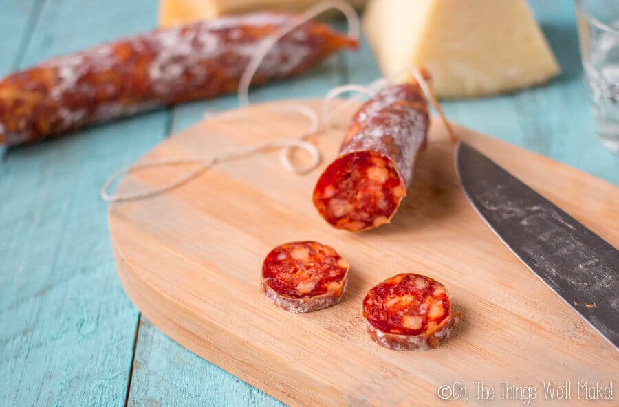  Homemade chorizo soon after it's safe to eat, being sliced on a bamboo cutting board.