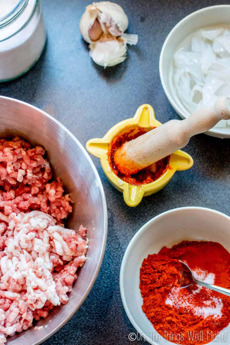 Ingredients for chorizo, ground pork, paprika, salt, garlic, and sausage casings being soaked in water