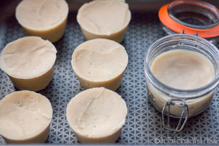 7 different homemade shave soaps. The 6 on the right were made in muffin tins while the one on the right was poured into a glass jar.