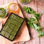 overhead view of homemade pesto sauce in a jar and in ice cube trays