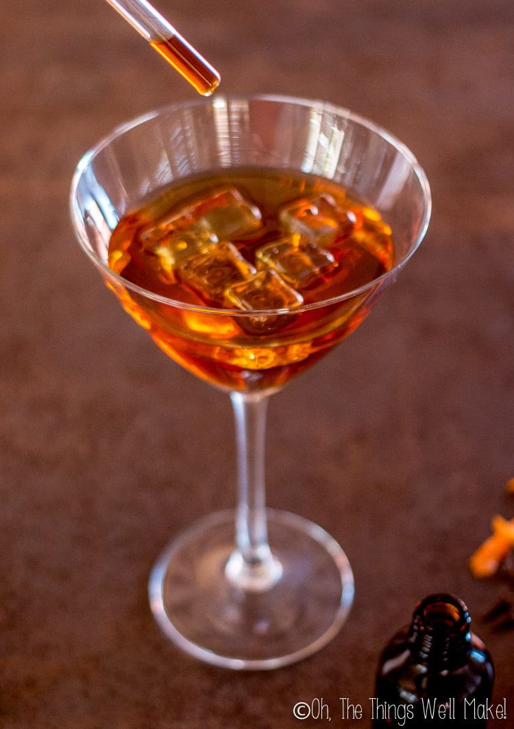 Drops of bitters being added to a cocktail