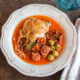 plate of basque chicken with olived, sun dried tomatoes and onions.