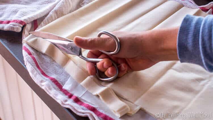 Cutting the layers of filo with scissors so that it fits the pan.