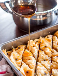 Pouring cool syrup over hot baklava